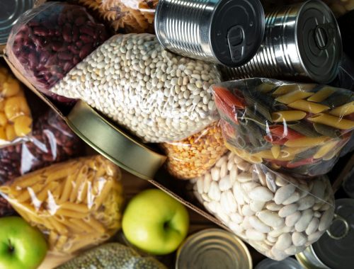 Donations food with canned food on the table background. Donate concept. Close up.